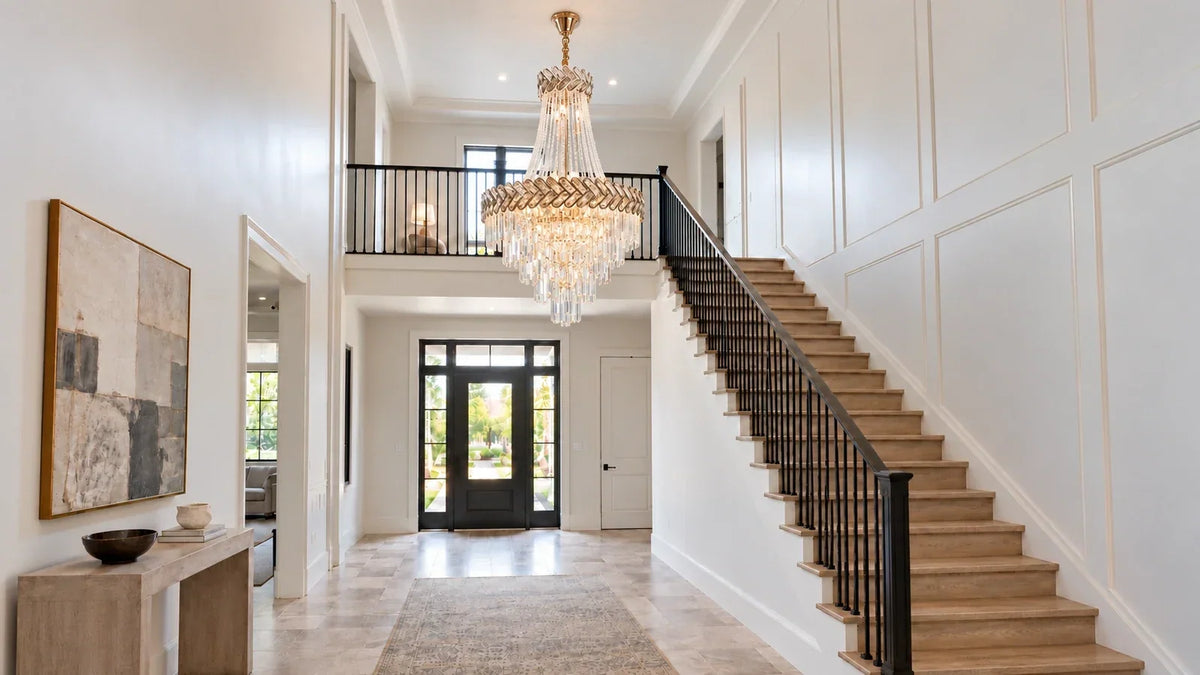 Tiered crystal chandelier with bead strands and an ornate metal rim in a double-height foyer.